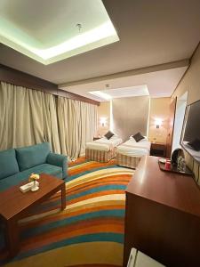 a hotel room with a couch and two beds at فندق بياب العزيزية - Beyab Azizia Hotel in Mecca +25 photos