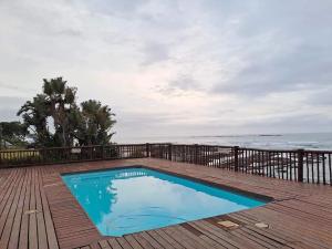 a swimming pool on a deck next to the ocean at Unit 18 Kei Sands Resort in Kei-mouth Village +16 photos