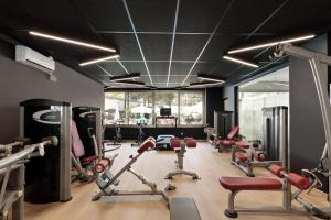 a gym with a lot of exercise equipment in a room at Hotel Best Oasis Park in Salou