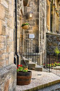 a stone building with flower pots on the side of a building at Snowdon Apartments in Stirling