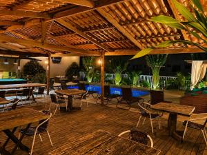 a restaurant with tables and chairs and a pool at Don Marcos Hotel com Pizzaria in Guarujá