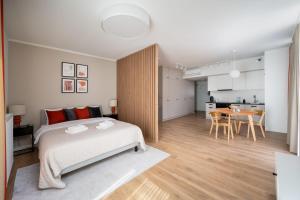 a bedroom with a large bed and a dining room at Unique Tower Business View Apartment in Warsaw