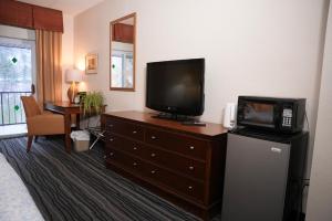 a hotel room with a television on a dresser at Kiteville Owego in Owego