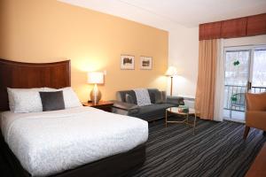 a hotel room with a bed and a chair at Kiteville Owego in Owego