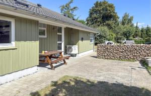 a picnic table outside of a house with a fence at Nice Home In Grenaa With Sauna in Grenå