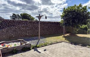 a wooden cross in a yard next to a brick wall at Nice Home In Grenaa With Sauna in Grenå