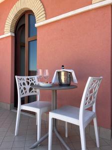 a table with two chairs and a pot on it at Hotel Ristorante Casa Rossa in Alba Adriatica