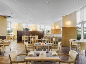 a dining room with tables and chairs and tablesktop at Hotel Oran Bay Managed By Accor in Oran