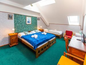 a bedroom with a bed and a desk and chairs at Hotel Paříž in Jičín +59 photos
