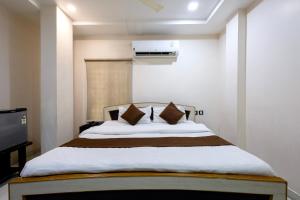 a bedroom with a large bed with two pillows at Hotel Aditya Grand in Guntūr