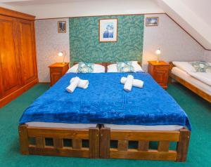 a bedroom with a blue bed with two towels at Hotel Paříž in Jičín