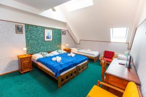 a bedroom with two beds and a table and chairs at Hotel Paříž in Jičín