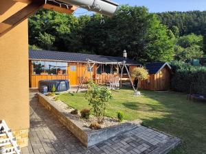 a backyard with a playground and a house at Chata Monika Veľké Pole in Veľké Pole