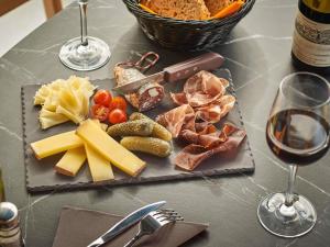 a table with a plate of cheese and meats and wine at ibis Bethune Centre Gare in Béthune