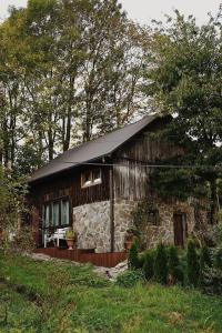 a small log cabin with a black roof at Domek na wyłączność w Otulinie Ojcowskiego Parku Narodowego in Wola Kalinowska