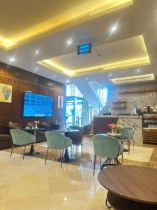 a restaurant with tables and chairs and a large screen at فندق بياب العزيزية - Beyab Azizia Hotel in Mecca