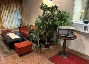 a room with plants and a table with a tv at ACE INN Itabashi in Tokyo