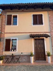 a house with a brown door and two tables at Liber Barbaresco House in Barbaresco