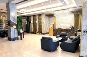 a lobby with chairs and a table in a building at Bloom Hotel in Baghdād