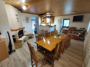 a dining room and kitchen with a wooden table and chairs at Chata Monika Veľké Pole in Veľké Pole