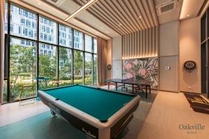 a pool table in a room with windows at Assana Cenang Beachview oakville by sync in Pantai Cenang