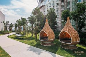 two metal sculptures sitting on the grass near a building at Assana Cenang Beachview oakville by sync in Pantai Cenang