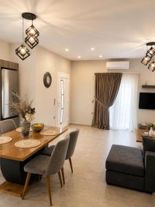 a dining room and living room with a table and chairs at Clio's house in Áyioi Dhéka