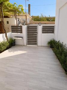 a patio with a white fence and a bench at Clio's house in Áyioi Dhéka