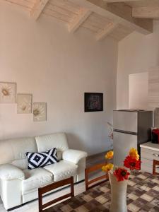 a living room with a white couch and a refrigerator at B & B Sotto al lago in Nemoli
