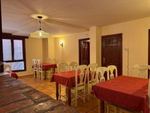 a dining room with tables and chairs and a chandelier at Casa Rural Villa Kora in El Burgo de Osma
