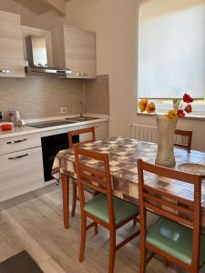 a kitchen with a wooden table with chairs and a tableasteryasteryasteryasteryastery at B & B Sotto al lago in Nemoli +9 photos