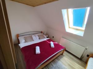 a bedroom with a bed with two towels on it at Chata Monika Veľké Pole in Veľké Pole