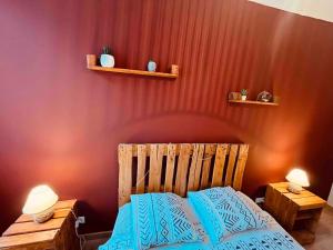 a bedroom with a wooden bed with blue pillows at Le Ch'ti Cambrai,Élégant, Centre ville in Cambrai