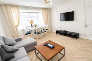 a living room with a couch and a table at Stylish 2BR House Parking & WiFi Sleeps 6 in Grangemouth