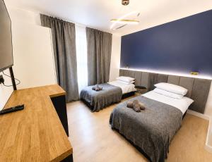 a hotel room with two beds and a table at Stylish 2BR House Parking & WiFi Sleeps 6 in Grangemouth