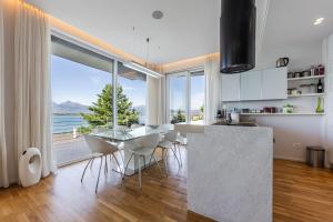 a kitchen with a table and chairs and a large window at Sunrise - The Twin Villa by PikHost in Shirokë
