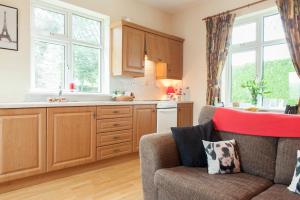 a kitchen with wooden cabinets and a couch in a room at Nick & Sandra's in Slane +37 photos