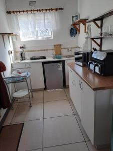 a small kitchen with white appliances and a table at The haven in George