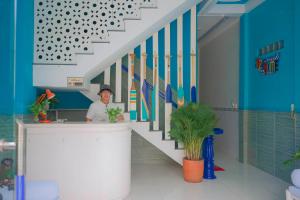 a man standing behind a counter in a bathroom at Gió Home Nhon Ly in Quy Nhon