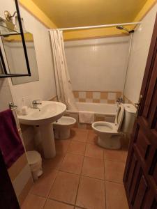 a bathroom with a sink and a toilet and a tub at Casa Rural Villa Kora in El Burgo de Osma