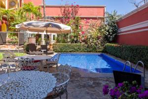 a patio with a table and an umbrella and a pool at Collection O Casa Bella Hotel Boutique, Cabo San Lucas in Cabo San Lucas +42 photos