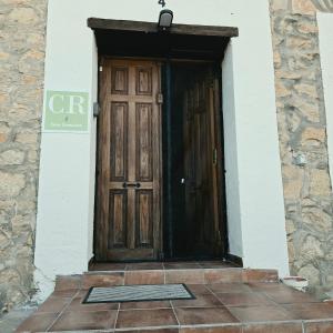 a wooden door of a house with a stone wall at Casa Rural El Jaral in Orihuela del Tremedal