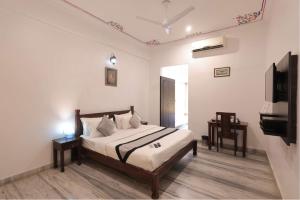 a bedroom with a bed and a tv in it at Atulya Niwas in Udaipur +65 photos