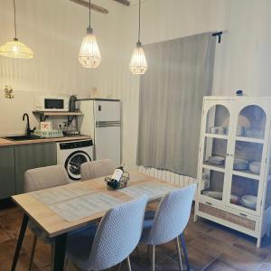 a kitchen with a table and chairs and a kitchen with a refrigerator at Casa Rural El Jaral in Orihuela del Tremedal