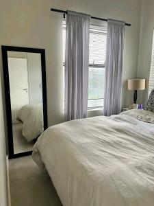 a bedroom with a large bed and a mirror at Ocean view in Johannesburg +5 photos