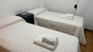 a room with three beds with white towels on them at Spa Valley II experiences Penthouse con Piscina climatizada y Yacuzzi in Villanueva de Río Segura +38 photos