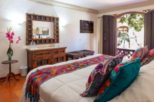 a bedroom with a bed and a desk and a mirror at Collection O Casa Bella Hotel Boutique, Cabo San Lucas in Cabo San Lucas