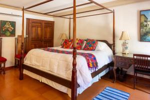 a bedroom with a four poster bed and a table at Collection O Casa Bella Hotel Boutique, Cabo San Lucas in Cabo San Lucas