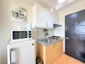 a small kitchen with a microwave and a sink at Compact Studio Unit l Mesaverte Residences 8th Floor in Pontud +7 photos