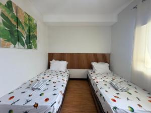 two twin beds in a small room with at Compact Studio Unit l Mesaverte Residences 8th Floor in Pontud